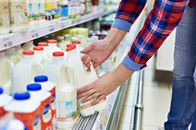 Shopper buying milk at grocery store